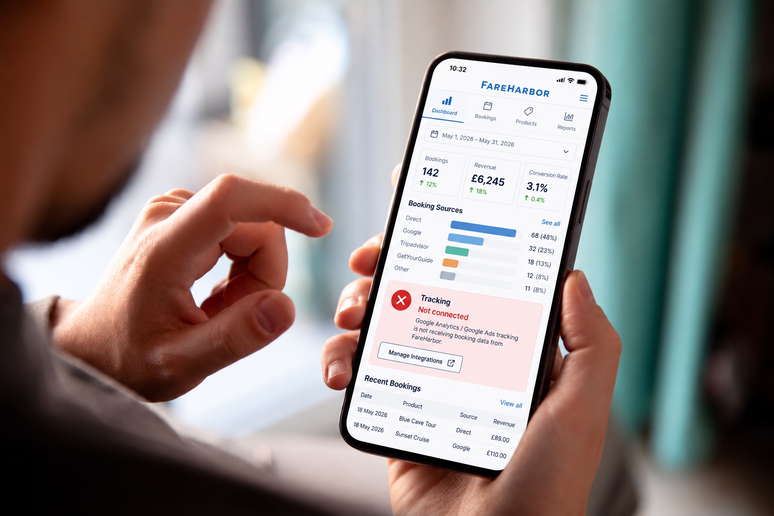 Tour operator checking a FareHarbor dashboard on a phone with a tracking not connected alert
